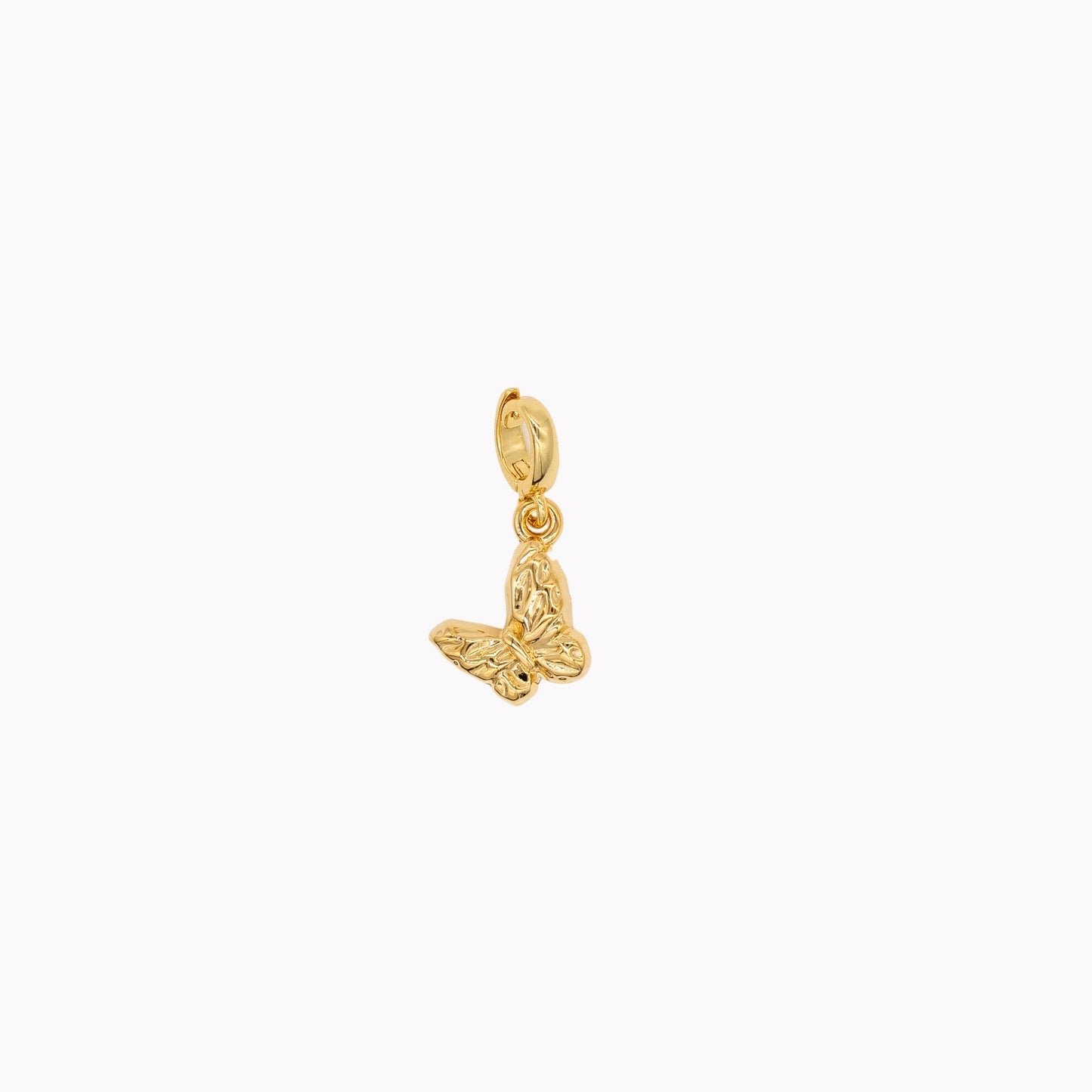 Gold butterfly pendant on a white background. Clip-on charm that can be opened and closed.