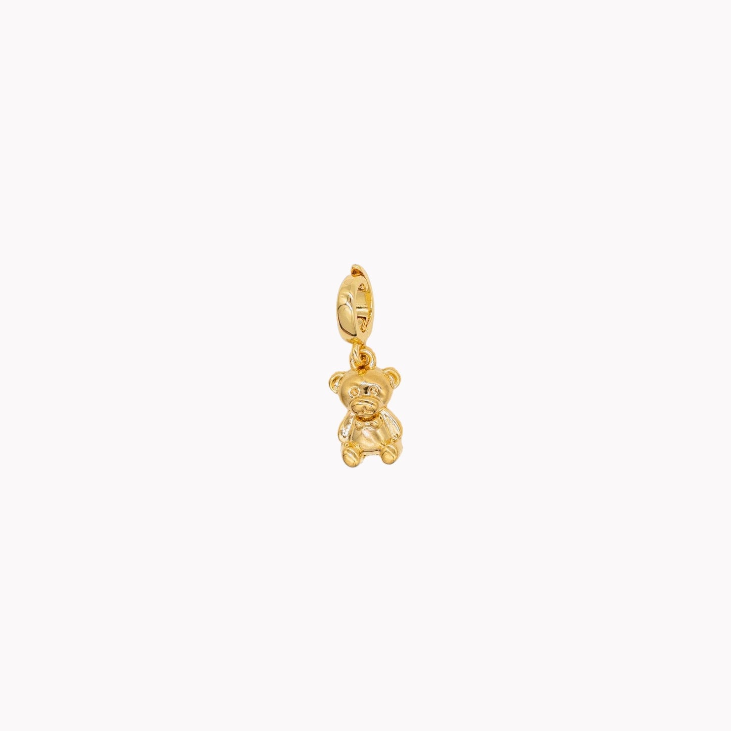 Gold teddy bear pendant on a white background. Clip-on charm that can be opened and closed.