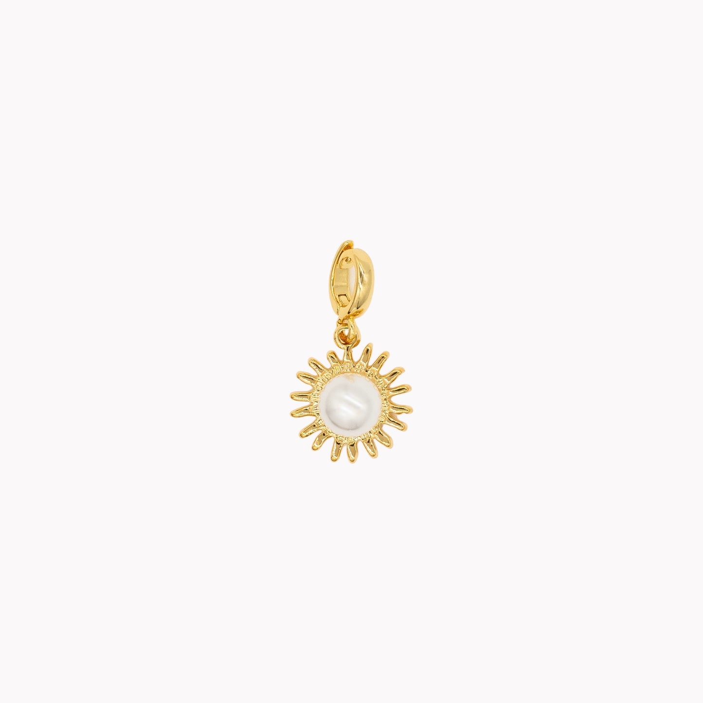 Gold sun-shaped pendant with a pearl center on a white background. Clip-on charm that can be opened and closed.