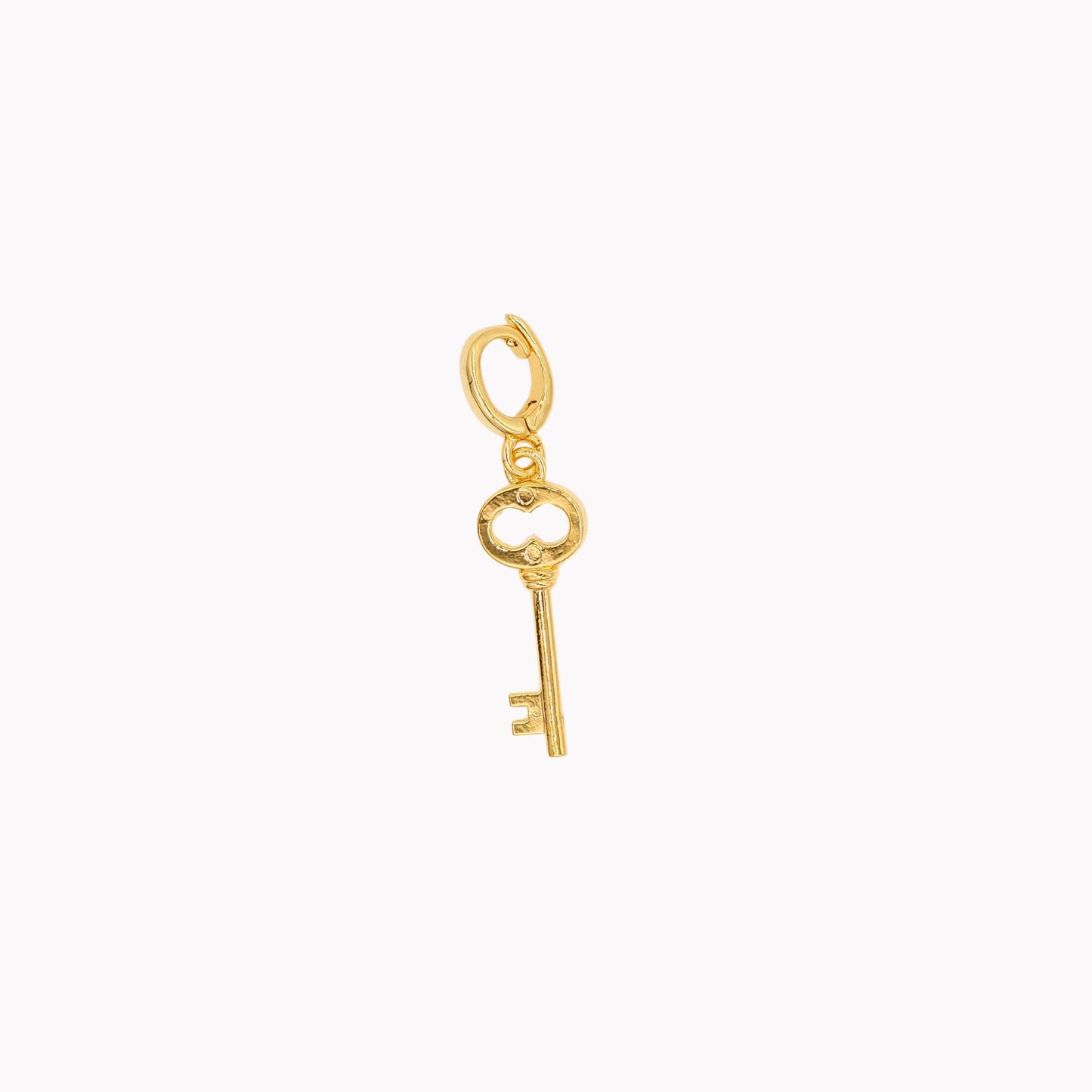 Gold key-shaped charm on a white background. Clip-on charm that can be opened and closed.