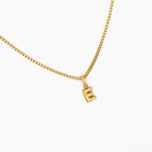 Gold "box" necklace with a 'E' pendant on a white background